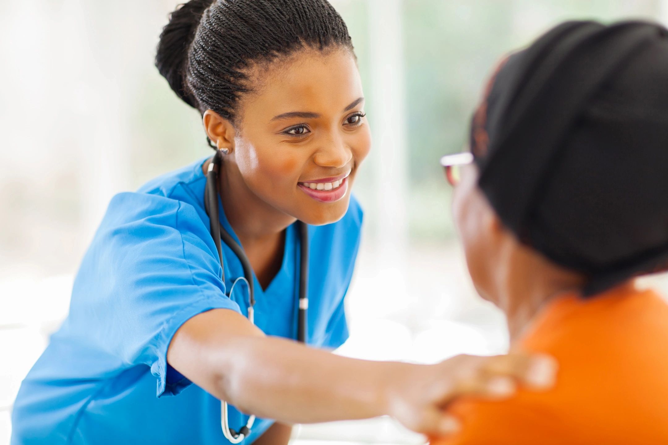 A nurse warmly checking on a patient in a caring manner.